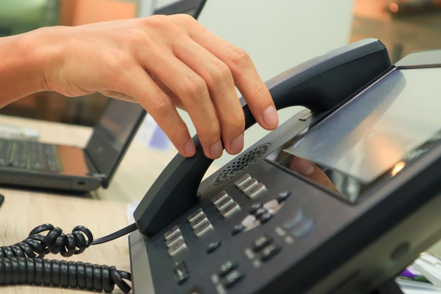 An employee answering up their VoIP phone.